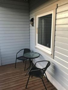 a porch with two chairs and a table and a window at Leilighet i Vadsø in Vadsø