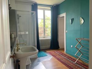 baño con bañera, lavabo y ventana en Clos des Minimes, en Blois