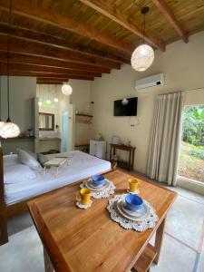um quarto com uma cama e uma mesa de madeira em Flor de Lis Chalés em Paraty
