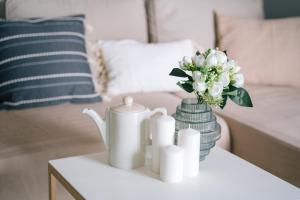 a white table with a vase of flowers and candles at Żoliborz Business Apartments by Rentujemy in Warsaw