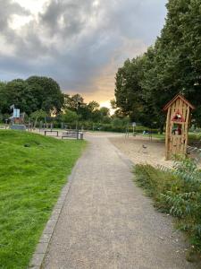 a path in a park with a small wooden structure at Marl Central Apartment in Marl