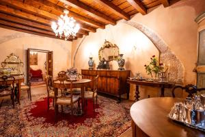 comedor con mesa, sillas y lámpara de araña en Villa Carrara La Spada, en Grezzana
