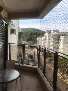 einen Balkon mit einem Tisch und Blick auf ein Gebäude in der Unterkunft Apartamento aconchegante e espaçoso! in Guarujá