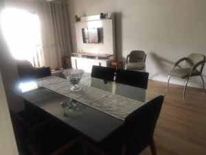 ein Esstisch und Stühle in einem Wohnzimmer in der Unterkunft Apartamento aconchegante e espaçoso! in Guarujá + 9 Fotos