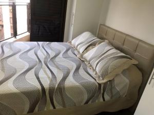 Bett in einem Schlafzimmer mit in der Unterkunft Apartamento aconchegante e espaçoso! in Guarujá