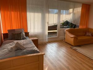 a bedroom with a bed and a couch and a window at Marl Central Apartment in Marl