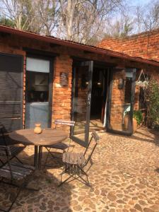 a patio with a table and chairs in front of a building at Mill Lane Farmhouse in Hartbeespoort