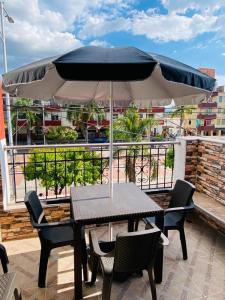 d'une table, de chaises et d'un parasol sur le balcon. dans l'établissement Apartamento Familiar Buga - Basílica señor de los milagros, à Buga