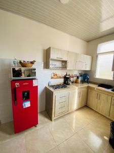 uma cozinha com um frigorífico vermelho e armários de madeira em Apartamento Familiar Buga - Basílica señor de los milagros em Buga