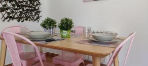 une table à manger avec des chaises roses et une table en bois dans l'établissement El Huertecito, à Navarredonda de Gredos