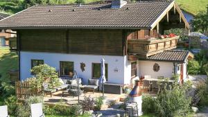 een klein huis met een veranda en een patio bij Ferienhaus Sommerbichl in Zell am See