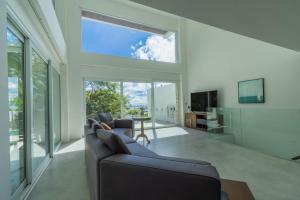 un soggiorno con divano e una grande finestra di seaview patong private pool sauna 4br villa a Patong Beach