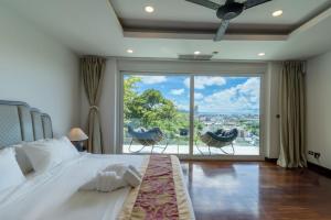 una camera con un grande letto e una grande finestra di seaview patong private pool sauna 4br villa a Patong Beach