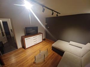 een woonkamer met een bank en een tv bij Apartments Marija in Rabac