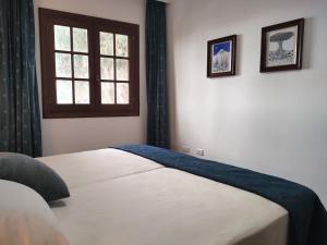 1 Schlafzimmer mit einem Bett mit Fenster und 2 Bildern in der Unterkunft Come Together in San Juan de la Rambla