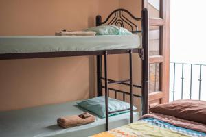 Hostal Encounter Guanajuato في غواناخواتو: سريرين بطابقين في غرفة مع نافذة