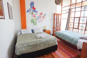 1 dormitorio con 2 camas y ventana en Native Soul Guesthouse, en Cusco