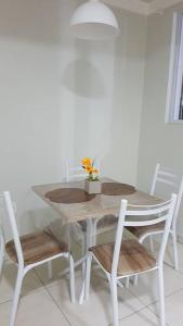 uma mesa de jantar com duas cadeiras e uma mesa com flores em Apartamento com 3 quartos! 7 camas no Centro em Lages