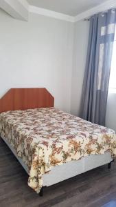 a bedroom with a bed with a floral bedspread on it at Apartamento com 3 quartos! 7 camas no Centro in Lages