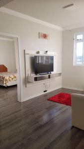 a living room with a flat screen tv on a wall at Apartamento com 3 quartos! 7 camas no Centro in Lages