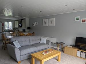 a living room with a couch and a table at Lovely Lakeside lodge for families and friends in South Cerney