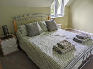 a bedroom with a bed with towels on it at Lovely Lakeside lodge for families and friends in South Cerney
