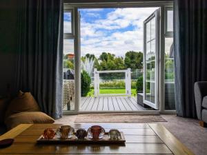 una sala de estar con una puerta que da a una terraza en Lovely Lakeside lodge for families and friends, en South Cerney