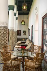 une chambre avec des chaises et une table fleurie. dans l'établissement Palais Riad Lamrani, à Marrakech