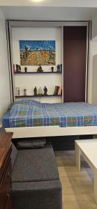 a bed in a room with a shelf at STUDIO 22M2 A IVRY/SEINE-A 200 METRES DE PARIS. PROCHE METRO 7 in Ivry-sur-Seine