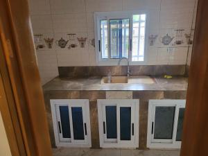 a kitchen counter with a sink and a window at MediSweet Apartments Meublés in Yaoundé