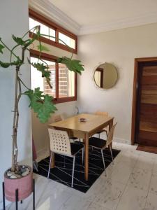 a dining room with a wooden table and a potted plant at Résidence Hadja 01 in Dakar