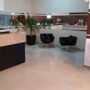 a lobby with two black chairs and a counter at Premium Palace Hotel in Ariquemes