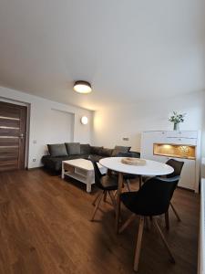 a living room with a couch and a table and chairs at Apartmán U Labe in Nymburk