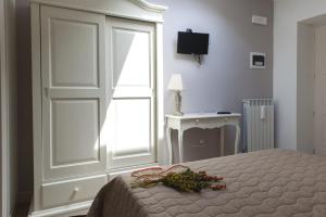 1 dormitorio con puerta, cama y escritorio en Villacolle Visso, en Visso