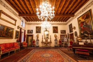 a living room with a chandelier and a room with paintings at Villa Carrara La Spada in Grezzana