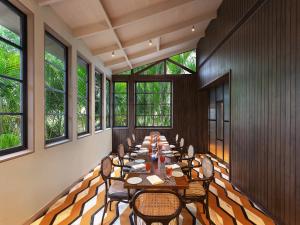 uma longa sala de jantar com mesas, cadeiras e janelas em ITC Grand Goa, a Luxury Collection Resort & Spa, Goa em Utorda