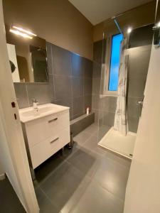 a bathroom with a white sink and a shower at Appartement 125m2 au centre de Cusset in Cusset +18 photos