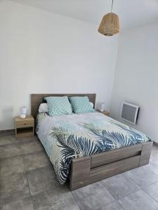ein Schlafzimmer mit einem Bett mit blauen Kissen darauf in der Unterkunft Appartement neuf, rez-de-jardin in Lucciana