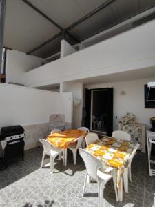 a dining room with a table and chairs and a stove at Stanze villa Morosini in Torre San Giovanni Ugento