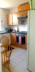eine Küche mit einem Kühlschrank, einem Tisch und einem Stuhl in der Unterkunft Ema apartment in London
