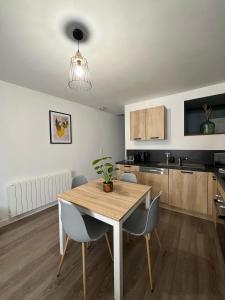 - une cuisine avec une table à manger et des chaises dans l'établissement Appartement Cosy, à La Châtre