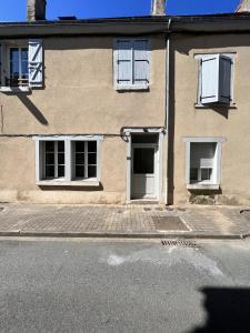 ein Gebäude mit einer Tür und Fenstern auf einer Straße in der Unterkunft Appartement Cosy in La Châtre