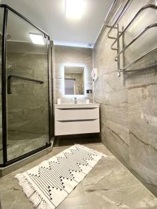 uma casa de banho com um chuveiro e um lavatório. em готель Вікторія em Volovets