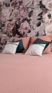 un letto con 2 cuscini e una parete floreale di Chez Pépère a Londinières