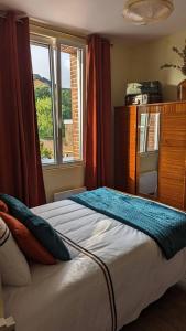 una camera da letto con un letto grande con una finestra di Chez Pépère a Londinières