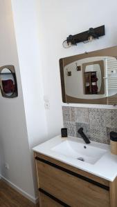un bagno con lavandino e specchio di Chez Pépère a Londinières Altre 34 foto