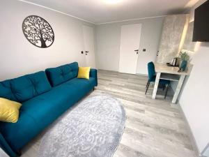 uma sala de estar com um sofá azul e uma mesa em готель Вікторія em Volovets