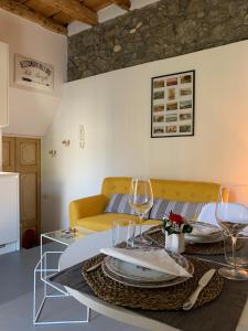 een woonkamer met een bank en een tafel met wijnglazen bij Villa Paola - Holiday Apartment - Menaggio, Lago di Como in Menaggio