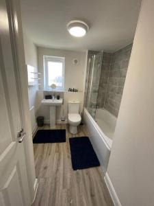 Un baño con inodoro, lavabo y ducha. en Luxurious Apartment in Brooklands, en Milton Keynes