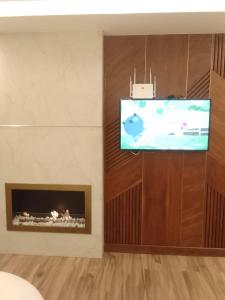 uma sala de estar com televisão e lareira em El fal em Dar Bouazza